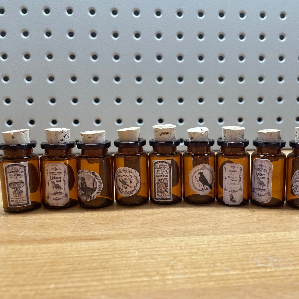 10 Small Brown Glass Bottles with Varying Apothecary Stickers Attached